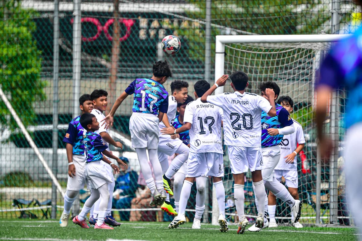 Players contest a header during a KFAM International Youth Cup match